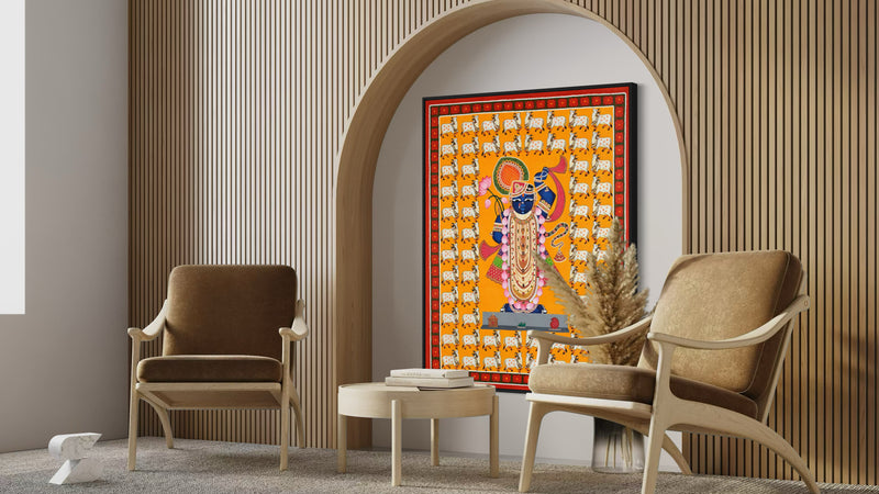 Shrinathji Pichwai framed art hung above a wooden console table in an Indian home